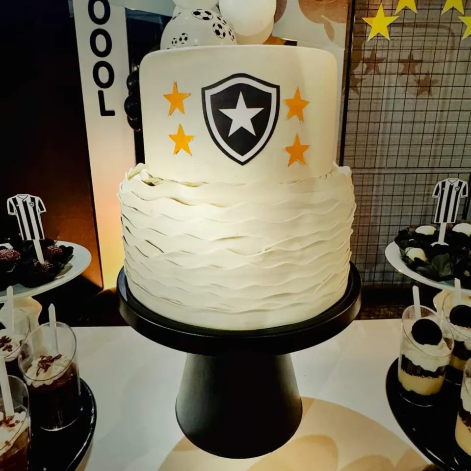 Bolo fake branco com escudo do Botafogo e estrelas douradas em uma montagem de futebol